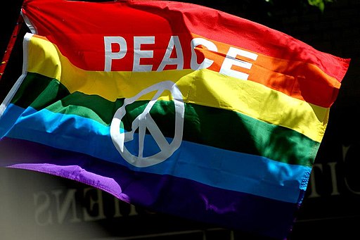 Rainbow flag with a white peace symbol